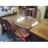 A dark stained Ercol elm dining table, together with four Ercol slat back dining chairs and two