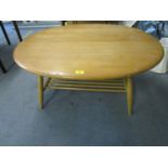 An Ercol elm and beech coffee table, model 4545, with magazine rack undertier, circa 1960, 17" x 39"