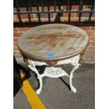 A white painted cast iron garden pub table with circular wooden top and pierced metal undertier,