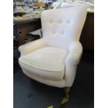 A contemporary Laura Ashley upholstered armchair, in cream fabric with button back, on turned