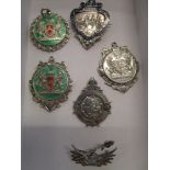 Silver and enamelled medals to include early 20th century silver examples and a badge fashioned as a