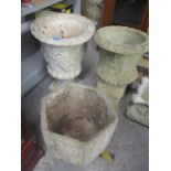 A composition stone garden urn shaped planter decorated with grapevines, together with two