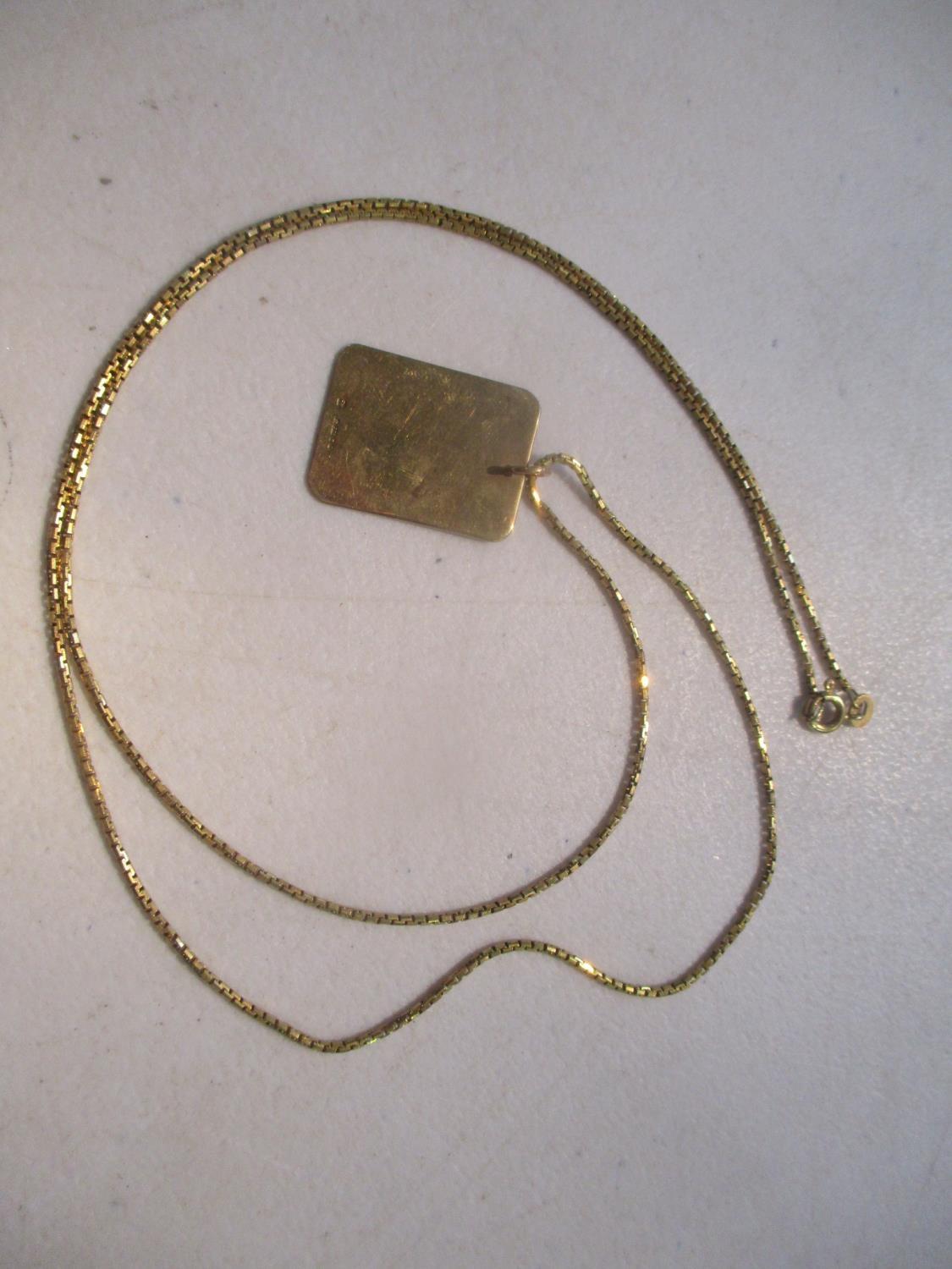 A 9ct gold tag pendant on an 18ct gold necklace