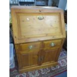 A modern pine bureau having a fall flap above two drawers and two cupboard doors 42 1/2" H x 30" W