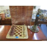 A granite and stone chess set and board, along with a Cornish serpentine turned table lamp
