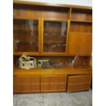 A mid 20th century teak large display cabinet sideboard having glazed doors above drawers and