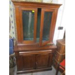 A Victorian mahogany cabinet having two glazed doors above a cushion moulded drawer and two cupboard