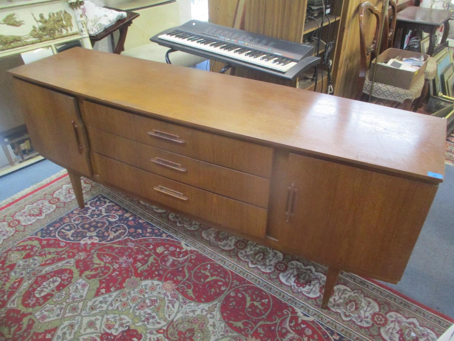 A mid 20th century retro teak sideboard having two cupboard doors, three drawers and on tapering