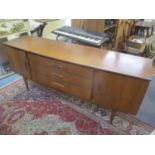 A mid 20th century retro teak sideboard having two cupboard doors, three drawers and on tapering