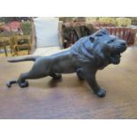 A signed Japanese patinated bronze spelter model of a lion with inset glass eyes 13 1/2" long A/F
