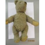 An early to mid 20th century mid brown and jointed teddy bear with long snout