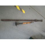 Circa WWII a Burmese bamboo and metal woodwind instrument, and an African carved wooden staff