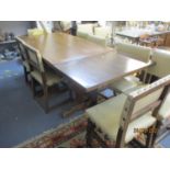 A 20th century oak pedestal table with extension, together with ten oak chairs having a cream