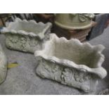 A pair of composition stone garden planters decorated with cherubs and floral swags 10" H x 16 1/