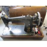 A 1940's Singer sewing machine in wooden case, serial no. EC647226 with accessories, together with