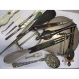 A silver backed hairbrush and implements to include tortoiseshell and mother of pearl items,