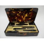 A 1920's tortoiseshell cased manicure set with silver gilt hinges and clasp by HA & Co London