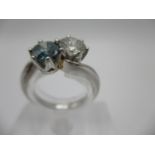 A platinum ring set with a round cut diamond 0.71ct and a round cut fancy vivid blue diamond, approx