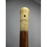 A 19th century walking stick with an ivory handle of knopped form carved with crosses and lines,