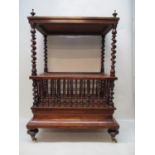 A Victorian walnut Canterbury having a fretworked gallery, over barleytwist columns and three