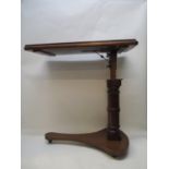 A Victorian mahogany reading table with and adjustable top, over a height adjustable column and