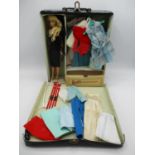 A 1963 Barbie Doll wearing a black patent travel wardrobe with assorted costumes and accessories,