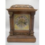 A late 19th/early 20th century oak cased mantle clock, having a carved case with a gilt dial,