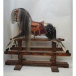 An early 20th century child's rocking horse with a mane, dappled, grey, black and white markings,