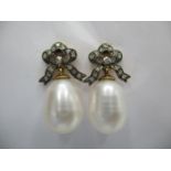 A pair of gold and silver earrings fashioned as bows set with diamonds and large pearl drops, boxed