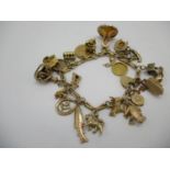 A 9ct gold bracelet with 9ct and gold coloured metal charms, a half sovereign and two fobs, one