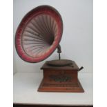 An oak cased table top gramophone with a Collaro B28 motor, a metal plaque to the front with a woman