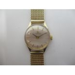 An Omega ladies 9ct gold manual wind wristwatch having a silvered dial with baton markers, the