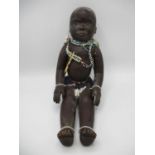 An Anglo African carved wooden doll with painted features, mobile limbs coloured glass bead