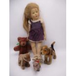 A German painted faced and cloth body doll with blond hair and a purple dress, 20" h, along with a