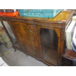 An early 20th century walnut cabinet having a central door flanked by two glass doors and on