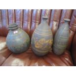 Three large pottery vases, two having an Aztec design