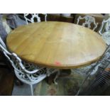 A large modern pine circular topped dining table