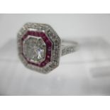 An 18ct white gold ring set with a central diamond, approximately 0.65ct with a band of rubies and a