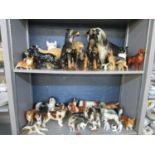 A collection of ceramic dog ornaments to include a group of Royal Doulton puppies in various playful
