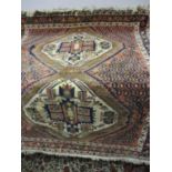 A Persian rug with a central medallion and hook motifs on a red and white ground 45" x 60"