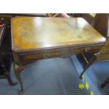 An early 20th century walnut twin drawer writing table having a leather top and standing on pad feet