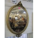 A late Victorian oval gilt framed wall mirror with scrolled leaf and styalized acanthus leaf