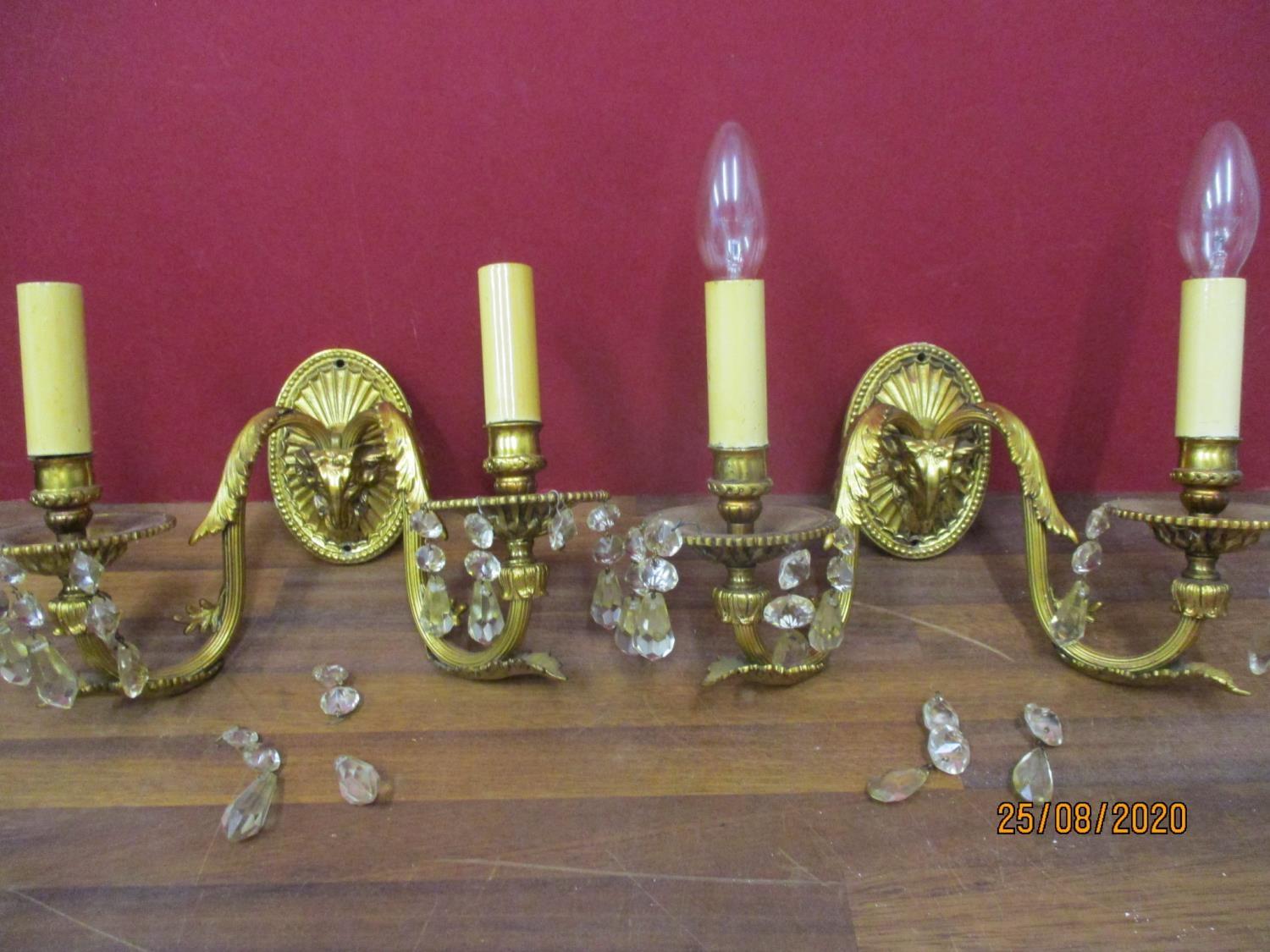 A pair of early 20th century gold painted metal wall lights A/F, with glass droplets and rams head