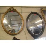 A Victorian ebonized oval mirror A/F, together with an oval gut mirror