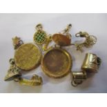 Gold and yellow metal charms to include a pill box fashioned as a seal and two lockets