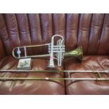 A Boosey & Hawkes Regent gold and silver coloured trombone, together with a Rosehill silver coloured