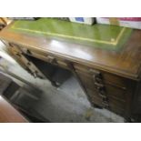An early 20th century oak desk having a green leather topped scriber, together with a French cream