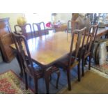 An early 20th century dining table and six matching dining chairs with brown leather drop in seats