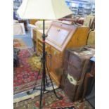 A mid 20th century black painted wrought iron standard lamp with later cream shade