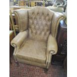A pair of leather button back wingback armchairs